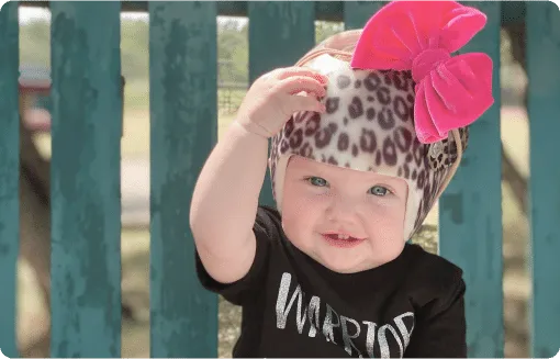 Baby wearing a flat head helmet for gentle skull correction therapy