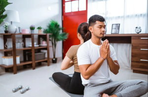 young couple practicing yoga exercises together in their living room to manage diabetes and improve flexibility